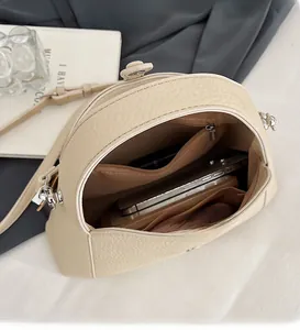 Detailed interior view of a beige litchi grain shoulder bag showing spacious storage