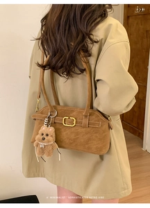 Brown retro leather shoulder bag with gold metal buckle and cute dog charm on a model