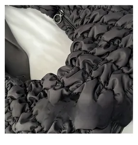 Gros plan détaillé d'un sac à bandoulière noir matelassé avec tissu plissé et fermeture éclair