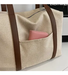 Detail einer langlebigen Canvas-Tragetasche mit praktischer Vordertasche und Ledergriffen