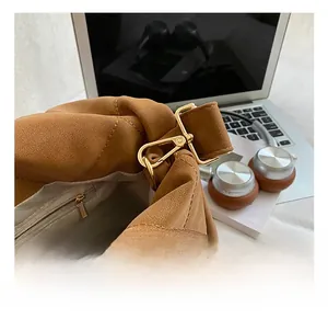 Detail of caramel brown quilted tote showing golden metal hook and inner zipper pocket