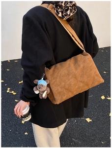 Quilted caramel brown crossbody bag with wide strap and cute teddy bear charm detail