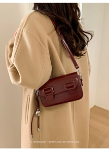 Minimalistische retro bordeauxrode crossbodytas gestyled met een beige wollen jas