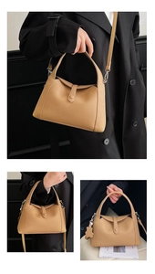 Detail view of light brown litchi pattern leather bag with flower charm and wide handle