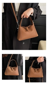 Detail of brown litchi pattern leather shoulder bag with a floral decorative pendant