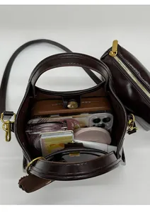 Vertical view of a brown vintage tote showing spacious interior with various daily items