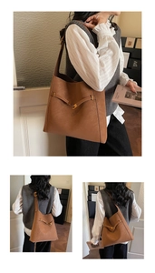 Detail view of large brown vintage leather tote bag with elegant gold buckle and strap