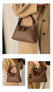 Close-up of brown litchi pattern leather bag with silver metal hardware and folding wings