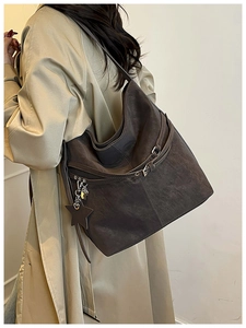 Gros plan d'un sac cabas en daim marron avec boucle métallique et pendentif en forme d'étoile