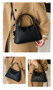 Close-up of black lychee grain leather underarm bag featuring premium metal buckle detail