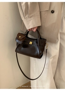 Detail view of dark brown retro leather handbag with gold buckle and matching coin purse
