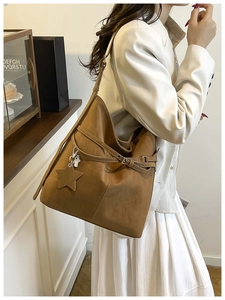 Détail de ce sac fourre-tout en daim marron avec pendentif étoile et boucle de ceinture