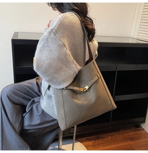 Detail view of taupe bucket tote bag featuring a gold buckle and textured matte finish