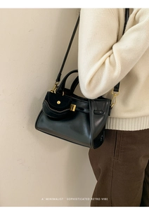 Detail of minimalist retro black tote with small pouch and gold hardware in scenario
