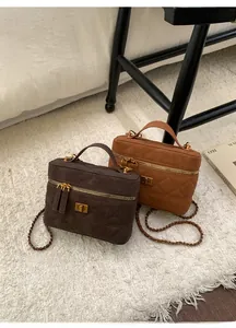 Detailed close-up of quilted coffee and caramel crossbody bags with gold metal hardware