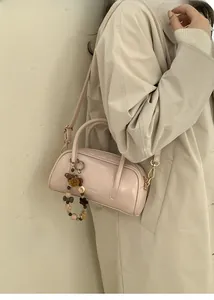 Detail of light pink patent leather Boston bag with vintage beads and crossbody strap