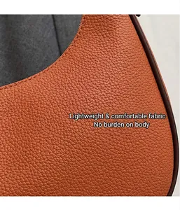 Detail der orangebraunen Ledertasche mit strukturierter Narbung und feinen Nähten
