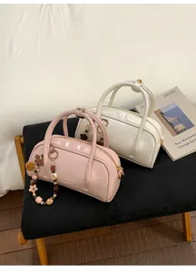 Top view of pink and white glossy PU leather Boston bags with decorative charms