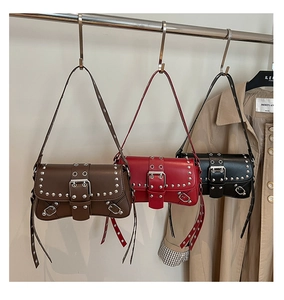 Detailed view of vintage studded shoulder bags in brown, red and black leather