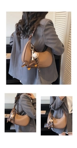 Detailansicht der braunen Tasche mit Baseball-Anhänger und Leder-Hundeanhänger