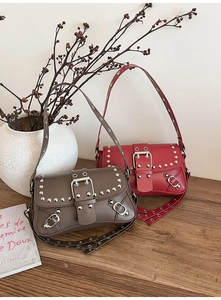 Close-up of vintage moto bags with silver studs and matte leather in red and brown