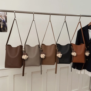 Group display of high-capacity bucket bags in five colors with plush dog charms