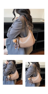 Detail der braunen halbmondförmigen Tasche mit Anhängern und verstellbarem Riemen