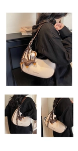 Detail der cremeweißen Tasche mit Litschi-Textur, Dackel- und Baseball-Anhängern