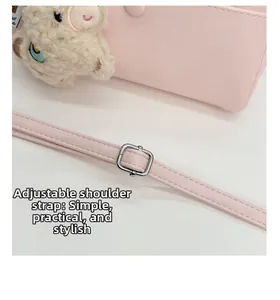 Detail of adjustable shoulder strap with silver buckle on pink Boston bag and charm