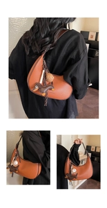 Detailansicht der Handtasche mit Litschi-Maserung und modischem Hundeanhänger