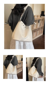 Detail of white tote bag showing pebbled leather texture and silver metal eyelets decoration