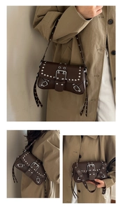 Detail view of dark brown punk rivet shoulder bag with metallic buckle and studs