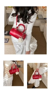 Detail of red cylindrical pillow bag with detachable strap and cute plush sheep charm