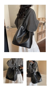 Detail of black matte leather tote bag with silver eyelets and rivets on shoulder strap
