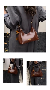 Detail of dark brown wax leather moon bag with wooden bead charm and logo print