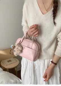 Pink PU leather bucket bag detail with plush bear charm and magnetic button pocket