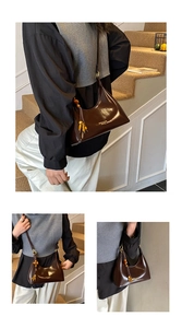 Detail of dark brown glossy hobo bag with wooden bead tassel and gold logo on leather