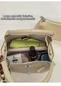 Interno spazioso della borsa a secchiello beige con pochette rimovibile per l'essenziale