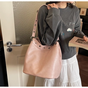 Detailed shot of pink faux leather tote bag with silver eyelets and matte texture