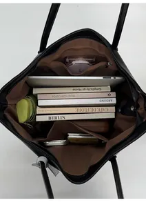 Interior view of large black tote bag showing spacious capacity for laptop and books