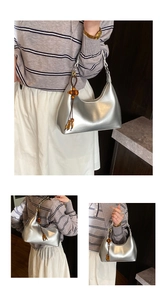Detailed close-up of a metallic silver hobo bag with unique wooden bead charm detail