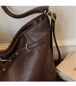 Close-up of vintage dark brown tote bag with retro metal ring buckle and fine stitching
