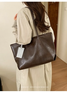 Minimalist large brown leather tote bag with retro crinkle texture and hanging tag