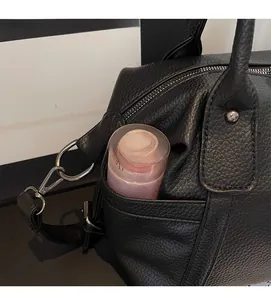 Detail of the practical side pocket on a black lychee texture leather shoulder bag