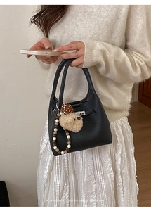 Dettaglio borsa in pelle martellata nera con chiusura argento e ciondolo a forma di cane