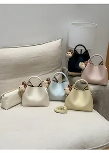 Detail of five-color bucket bags with bear charms and inner pouches on a sofa