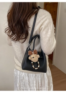 Borsa a secchiello nera con trama litchi e ciondolo orsetto di peluche per donna