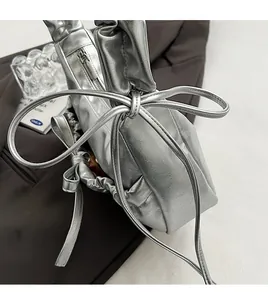Detail of silver metallic drawstring handbag with pleated texture and bow design