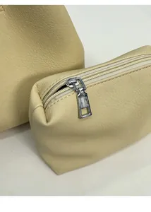 Detail of beige bucket bag and matching zipper pouch in pebble-textured faux leather