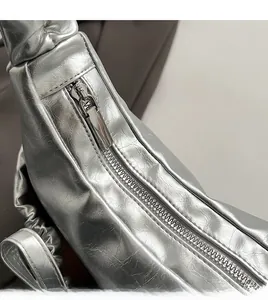 Detail of silver metallic shoulder bag showing crinkled texture and smooth metal zipper